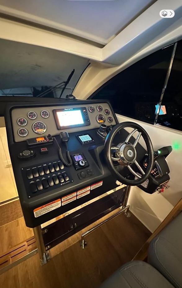 Painel Raymarine, instrumentos e volante esportivo.