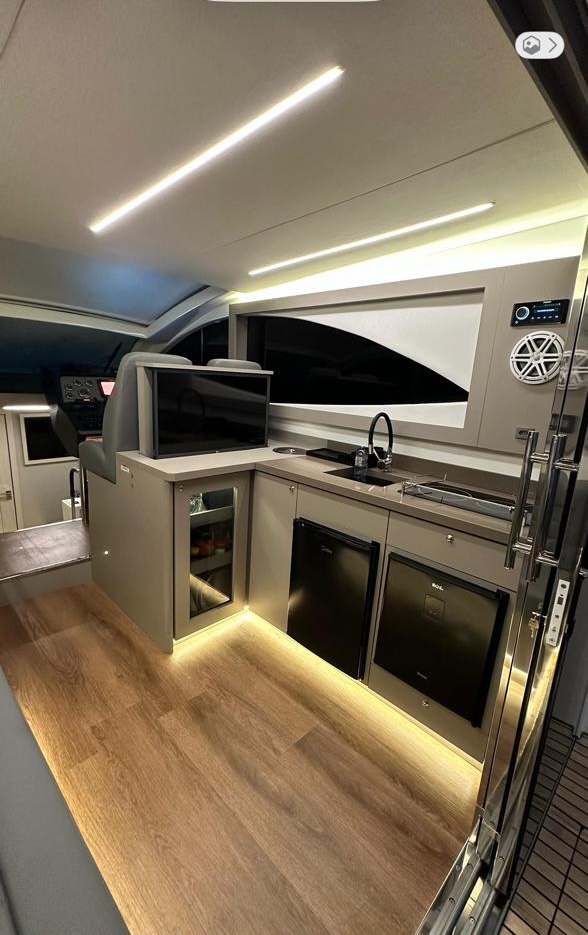 Cozinha integrada com TV e janela panorâmica.