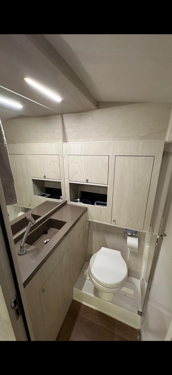 Banheiro completo com sanitário, pia e armários.